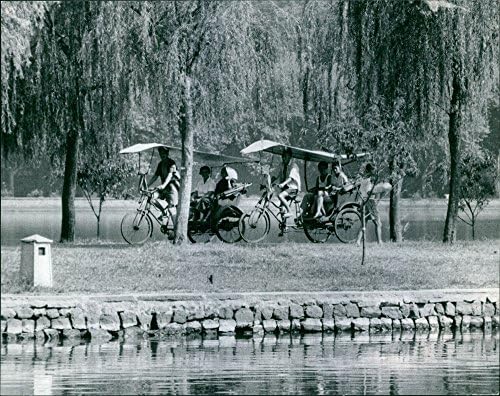 Реколта картина на хората, минаващи по брега на езерото в рикшах.